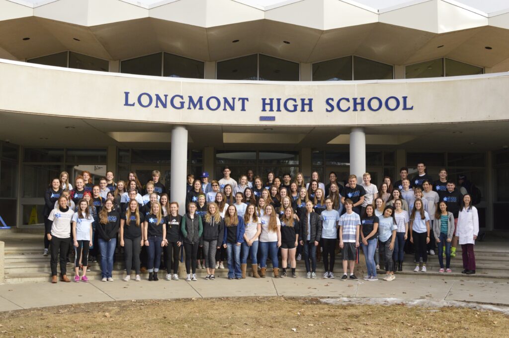 Photo of students posing for a group photo in front of Longmont High